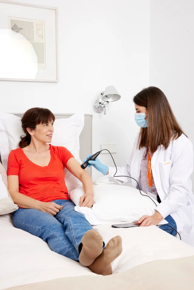 Profesional médico colegiado atendiendo a un paciente en su domicilio en Madrid con atención personalizada.